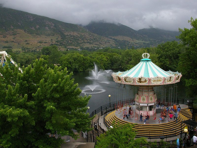 Turn of the Century swing ride and lagoon at Lagoon amusement park, Farmington, Utah, with the Wasatch foothills behind