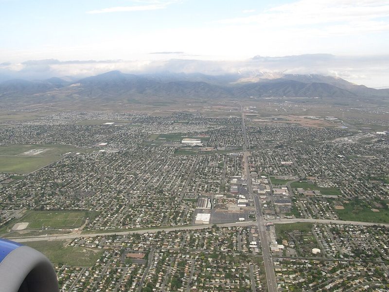 Aerial view of Kearns neighborhoods and the Utah Olympic Oval with the Wasatch Mountains beyond