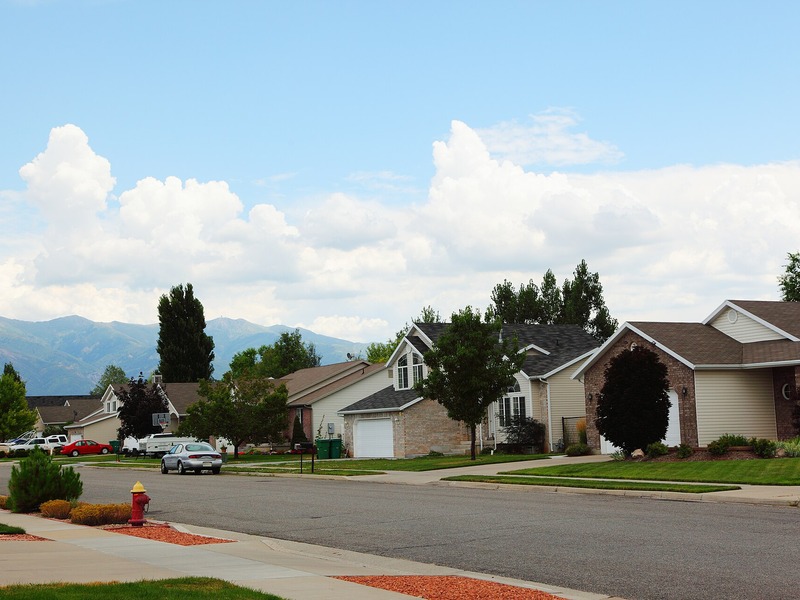 Suburban Layton, Utah neighborhood with lawns, trees, and the Wasatch Mountains beyond
