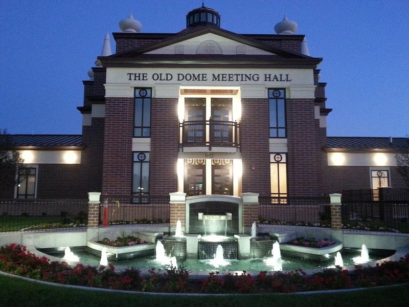 The Old Dome Meeting Hall and illuminated fountain in Riverton City Park at dusk